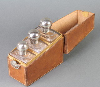 A wedge shaped leather case containing 3 silver plated mounted glass botttles