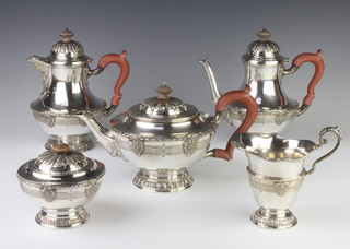 A fine cast and chased silver 5 piece tea and coffee et comprising teapot, coffee pot, hot water jug, sugar bowl with lid and milk jug, London 1978, maker Mappin & Webb, with fruitwood handles, gross weight of 3783 grams  