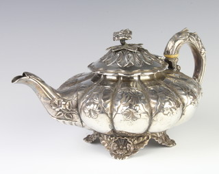 A George IV silver fluted melon shaped repousse teapot decorated with flowers, raised on scroll feet, London 1828, maker Charles Thomas Fox, gross weight 763 grams  