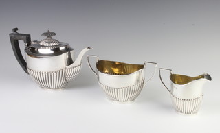A matched silver demi-fluted tea set with ebony mounts, Birmingham 1923, 1924, gross 632 grams 
