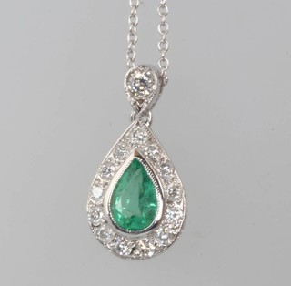 An 18ct white gold pear cut emerald and diamond pendant, the emerald 0.5ct surrounded by brilliant cut diamonds, 18mm x 9mm, hung on an 18ct white gold chain 