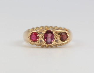 An 18ct yellow gold garnet and diamond ring size N 1/2, 2.7 grams