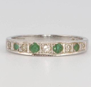 An 18ct white gold emerald and diamond half hoop ring, size M 1/2, 3.2 grams