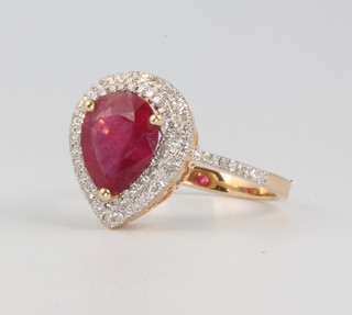 A 14ct yellow gold pear shaped ruby and diamond ring, the treated centre stone approx. 3.02ct surrounded by brilliant cut diamonds approx. 0.46ct, size m 