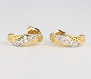 A pair of 18ct yellow gold diamond scroll ear clips 3.9 grams