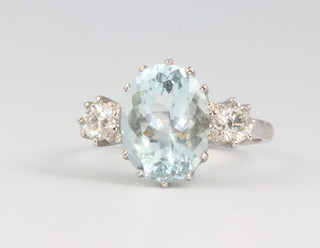 A platinum oval aquamarine and diamond ring, the centre stone approx. 4.5ct flanked by 2 brilliant cut diamonds approx. 0.55ct, size K 