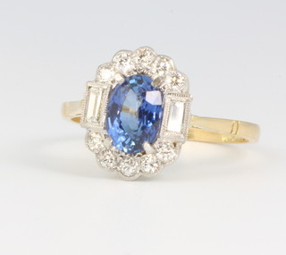 An 18ct yellow gold oval sapphire and diamond cluster ring, the centre stone approx. 1.6ct flanked by brilliant and baguette cut diamonds approx 0.45ct, size P 1/2 