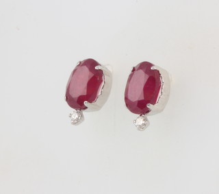 A pair of platinum oval treated ruby and diamond ear studs, the rubies approx. 4ct, the diamonds 0.06ct 