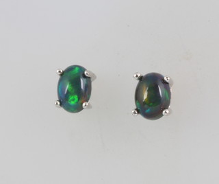 A pair of black opal ear studs