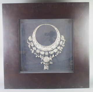 An Eastern "silver" coated in bronze replica Miao necklace, contained in a glazed frame, measurement of necklet as displayed 36cm h x 35cm w 