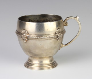 A silver pedestal mug with fancy scroll handle, Birmingham 1928, weighs 188 grams