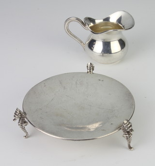 A Continental silver circular dish raised on seahorse legs together with a silver miniature jug, 106 grams 