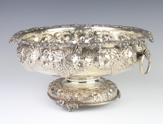 A Continental repousse silver pedestal bowl decorated with grapes and vines with circular ring handles, 1388 grams, 32cm 