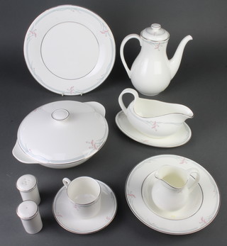 A Royal Doulton Carnation pattern coffee and dinner service comprising coffee pot, 6 coffee cans, 6 saucers, 8 small plates, 8 medium plates, 6 dinner plates, a sandwich plate, 6 dessert bowls, 5 soup bowls, a sauce boat and stand, 2 tureens and lids, milk jug, 8 napkin rings, 2 condiments 