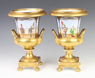 A pair of 19th Century Paris porcelain 2 handled vases decorated with panels of figures beneath an arcaded terrace with gilt mask handles, raised on claw feet 26cm  