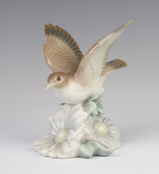 A Lladro figure of a bird sitting on a flower 14cm 
