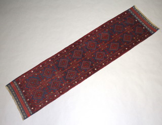 A blue and red ground Meshwani runner with 16 stylised diamonds to the centre within a multi row border 254cm x 65cm 