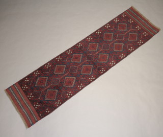 A red and blue ground meshwani runner with 19 stylised diamonds to the centre 250cm x 68cm 