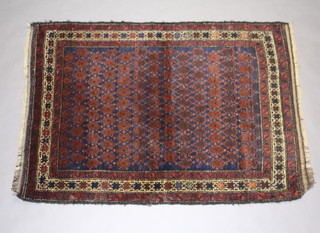 A red and blue ground Baluchi rug with all over geometric design within a 3 row border 138cm x 99cm 