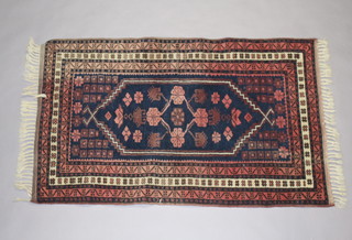 A blue and red ground Persian rug with central medallion within a multi row border 130cm x 80cm 