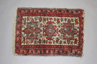 A white and red ground Persian slip rug with diamond medallion to the centre within a multi row border 82cm x 60cm 