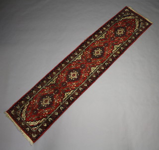 An Afghan red and white ground floral patterned runner with 4 medallions to the centre within a multi row border 335cm x 75cm 
