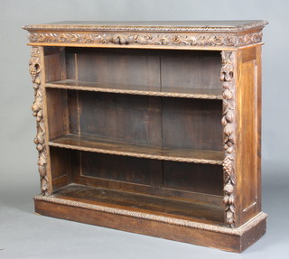 A Victorian carved oak bookcase, the interior fitted adjustable shelves raised on a platform base 115cm h x 127cm w x 36cm d 
