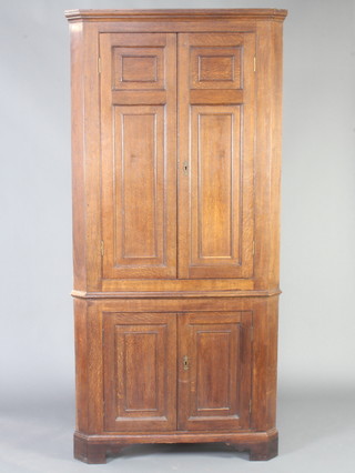 An 18th Century oak double corner cabinet with moulded cornice, both sections fitted shelves enclosed by panelled doors, raised on bracket feet 203cm h x 98cm w x 68cm d 