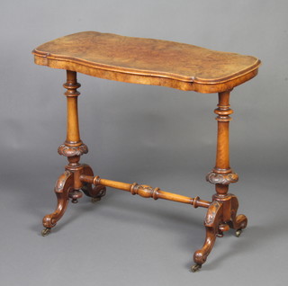A Victorian figured walnut centre table of serpentine outline, raised on turned supports with carved H framed stretcher 72cm h x 83cm w x 48cm d 