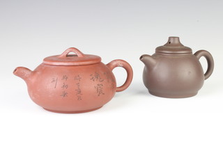 A Tanware teapot with incised flowers and script 16cm, a dark tan ditto 12cm 