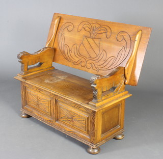 A 1930's carved light oak monks bench with lion arms, raised on bun supports 60cm h x 105cm w x 45cm d 