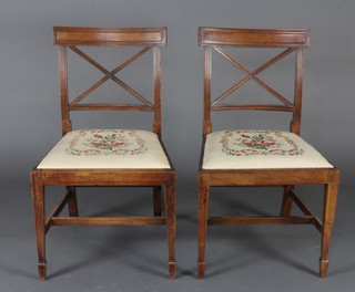 A pair of Georgian mahogany bar back dining chairs with X framed backs and upholstered drop in seats, raised on square tapered supports 