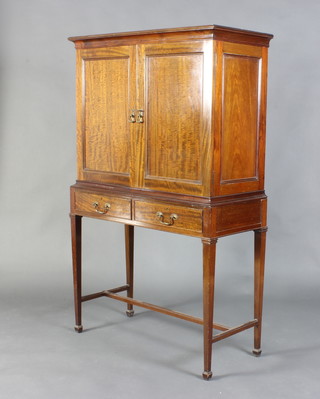 Library Company of Regent Street London, an Edwardian Georgian style mahogany cabinet with moulded cornice, the interior fitted 14 shallow trays enclosed by a pair of panelled doors, the base fitted 2 short drawers, raised on square tapered supports with H framed stretcher 144cm h x 90cm w x 40cm d 