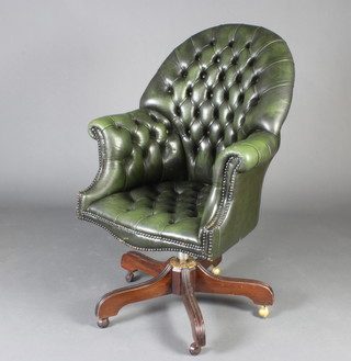 A Victorian style tub back revolving office chair upholstered in green buttoned leather 