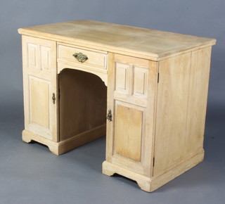 An Edwardian Art Nouveau bleached oak dressing table fitted a drawer above pair of cupboards fitted a drawer and 3 shallow trays enclosed by a pair of panelled doors, raised on bracket feet 77cm h x 107cm w x 70cm d  