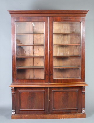 A Victorian mahogany library bookcase with moulded cornice, the upper section fitted shelves enclosed by glazed panelled doors, the base enclosed by double panelled doors with vitruvian scrolls to the sides 225cm h x 162cm w x 47cm d 
