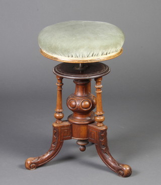 A Victorian carved walnut circular revolving adjustable piano stool, raised on 3 outswept supports 