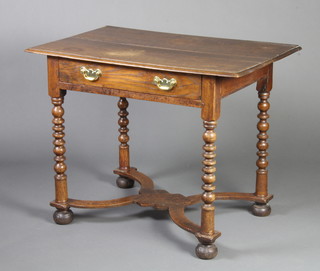 An 18th Century oak side table fitted a frieze drawer with brass swan neck drop handles, raised on bobbin turned supports with X framed stretcher on bun feet 71cm h x 91cm w x 57cm d 