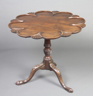 A George III shaped circular mahogany supper table with scallop edge, raised on a turned column and tripod base 70cm h x 82cm diam. 