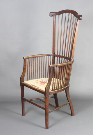 An Arts and Crafts mahogany stick and rail back armchair with Berlin woolwork seat raised on square tapered supports 