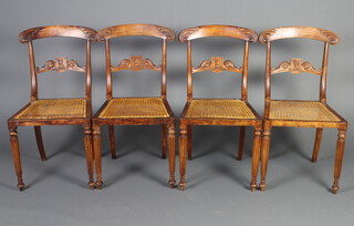 A set of 4 William IV mahogany bar back dining chairs, the mid rail carved an armorial figure with woven rush seats, raised on turned and fluted supports 