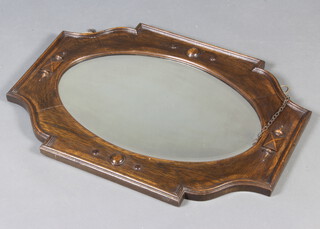 An Edwardian oval bevelled plate wall mirror contained in a shaped oak frame with geometric mouldings 56cm x 75cm 