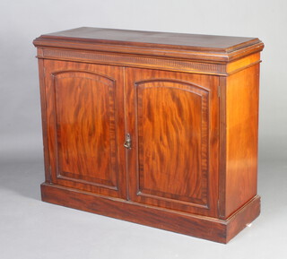 A Victorian mahogany side cabinet with fluted decoration, fitted a shelf enclosed by arched panelled doors, raised on a platform base 100cm h x 120cm w x 44cm d 