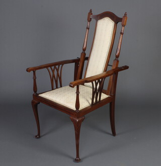 An Edwardian inlaid mahogany open arm reclining chair upholstered in green material, raised on cabriole supports 