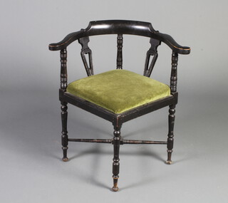 A Victorian ebonised corner chair with turned and splat back and upholstered drop in seat, raised on turned supports with X framed stretcher