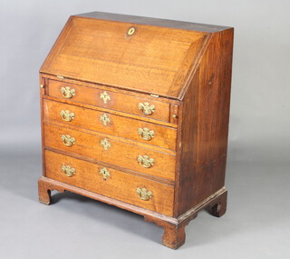 A George III oak bureau with fall front revealing a fitted interior above 4 long graduated drawers with replacement handles, raised on bracket feet 105cm h x 91cm w x 51cm d   