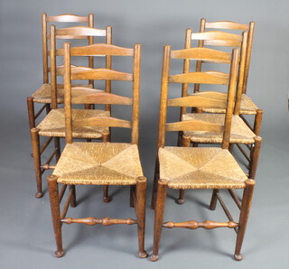 A set of 6 18th Century style elm ladderback dining chairs with woven rush seats raised on club supports 