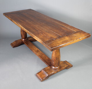 An elm refectory style dining table, the top formed of 5 planks, raised on turned supports with H framed stretcher 75cm h x 183cm l x 70cm w 