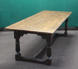 A 17th Century style elm refectory dining table raised on cup and cover supports 74cm h x 244cm l x 92cm w 
