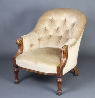 A Victorian bleached mahogany tub back chair upholstered in mushroom buttoned material, raised on turned and fluted supports  